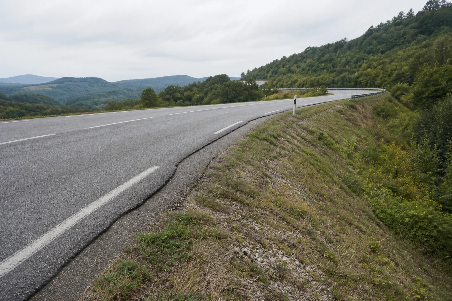 Route de relief soutenue par un ouvrage en terre présentant un affaissement localisé.